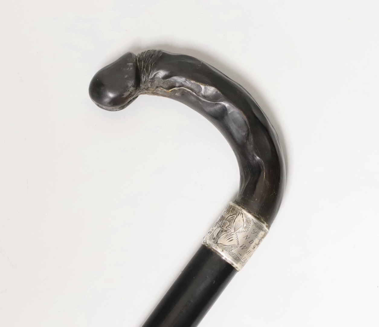 A silver mounted ebony cane with a phallic shaped handle, presented by N.D.T. Chapel to W.H. Miles, 1899. 82cm high